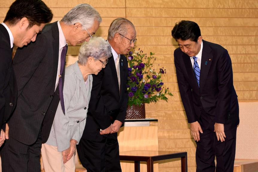A group of Japanese people bowing to each other