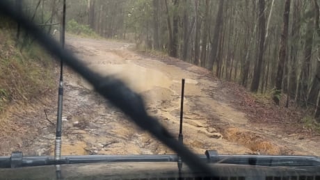 Photo from the driver's side of a car driving on a muddy road