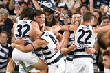 Geelong players celebrate in front of their fans after beating Brisbane in their AFL preliminary final.