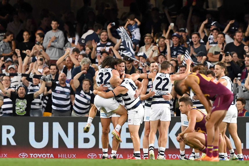 Geelong players celebrate in front of their fans after beating Brisbane in their AFL preliminary final.