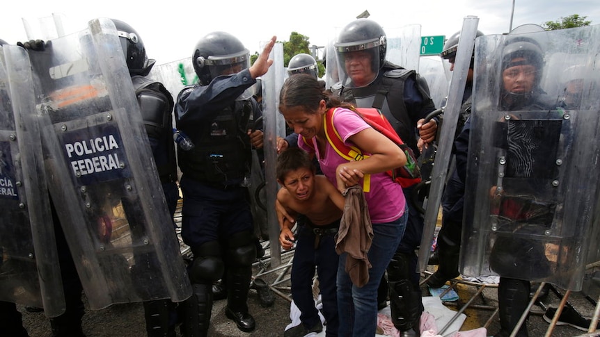 A Honduran migrant mother and child cower in fear.