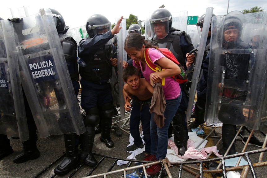 A Honduran migrant mother and child cower in fear.