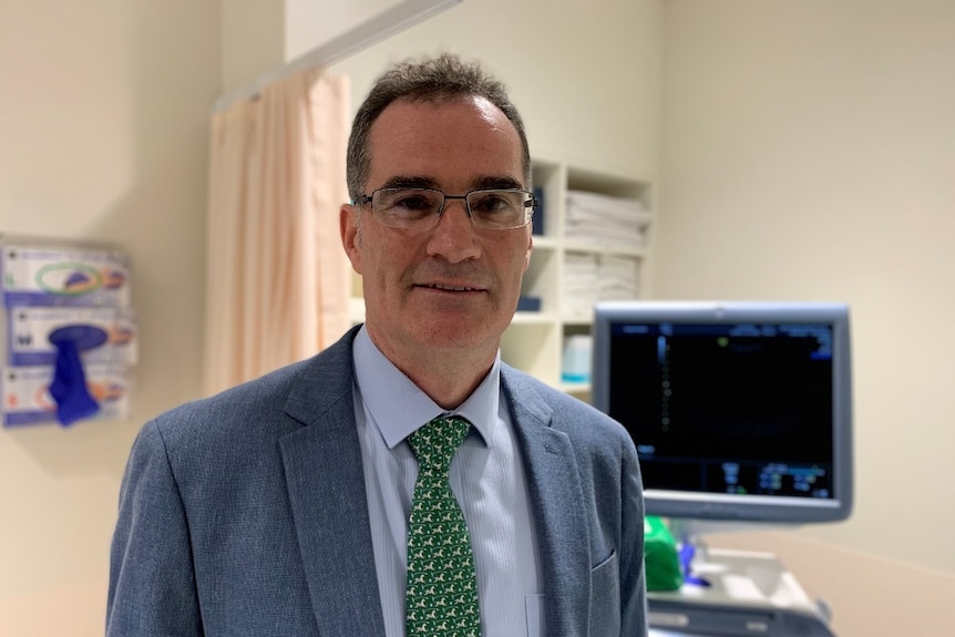 Mater Hospital obstetrician and gynaecologist Luke McLindon stands in front of medical equipment.