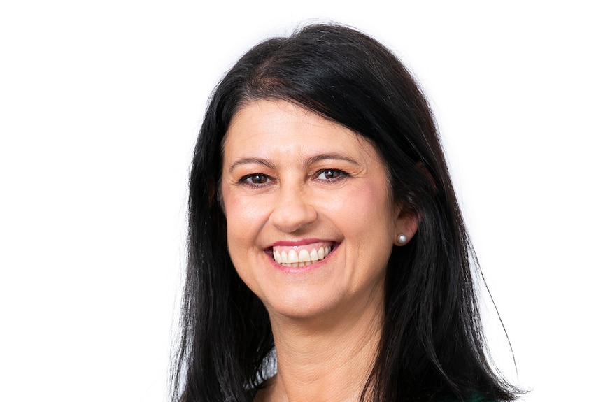 A dark-haired woman smiles for a professional portrait.