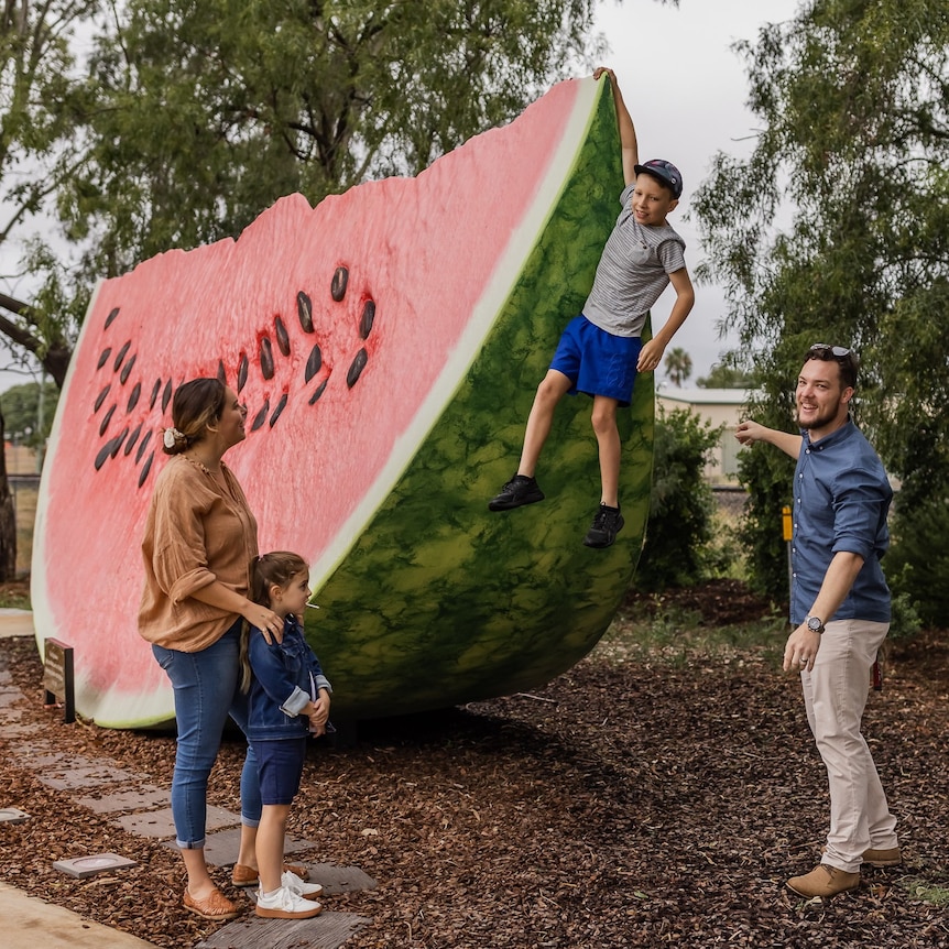 family group playing on and around a giant watermelon in Chinchilla