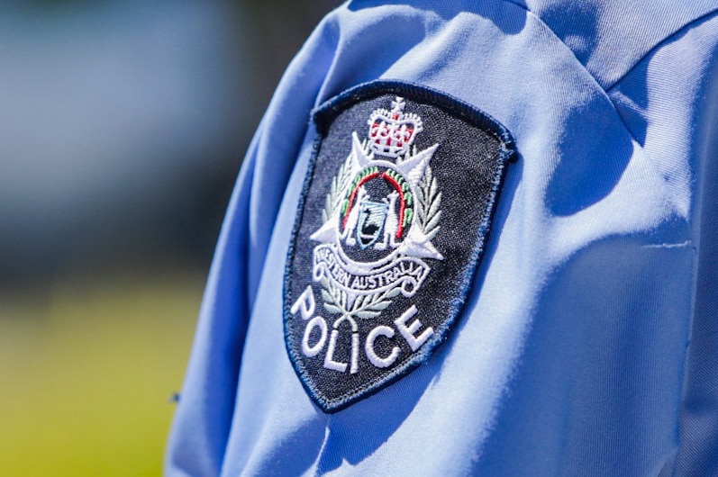 A WA Police badge on an officer's shirt shoulder.