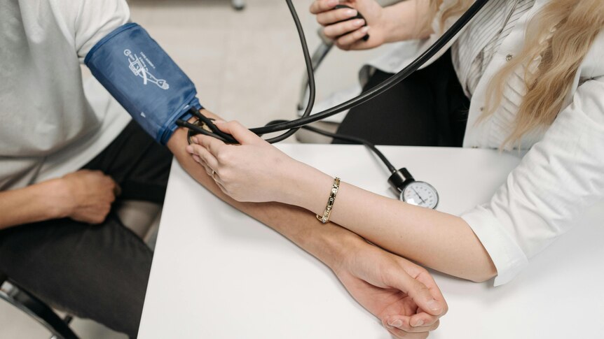 Dr taking blood pressure of a patient 