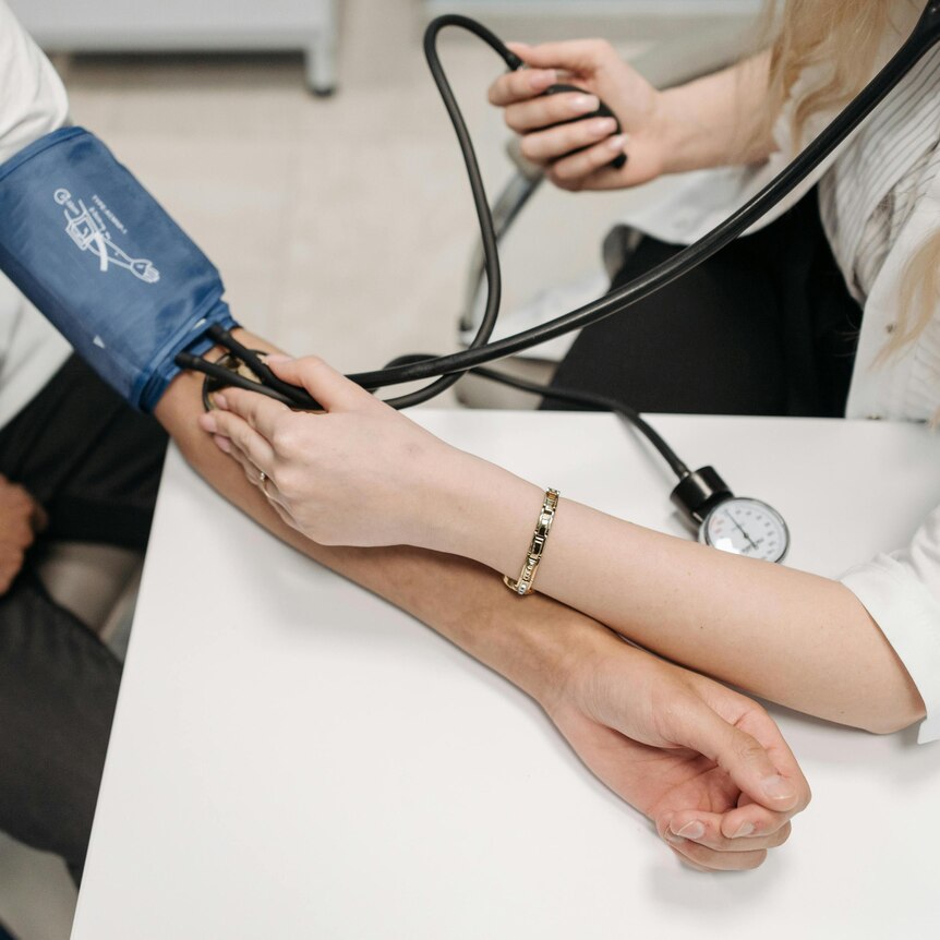 Dr taking blood pressure of a patient 