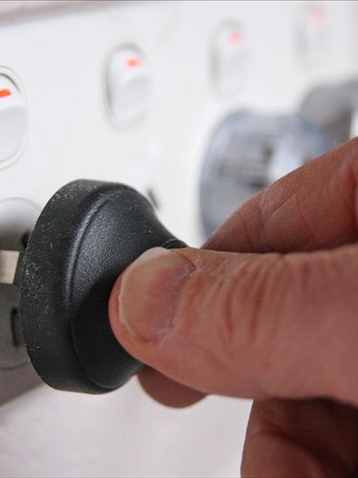 A hand puts a plug into an electric socket