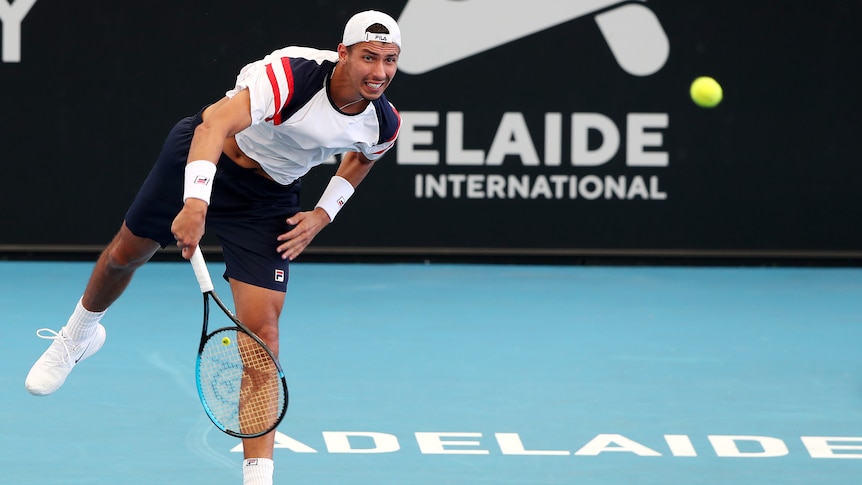 An Australian professional male tennis player serves the ball at the Adelaide International.
