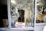 A man removes broken glass from a window of Thai honorary consulate in Istanbul