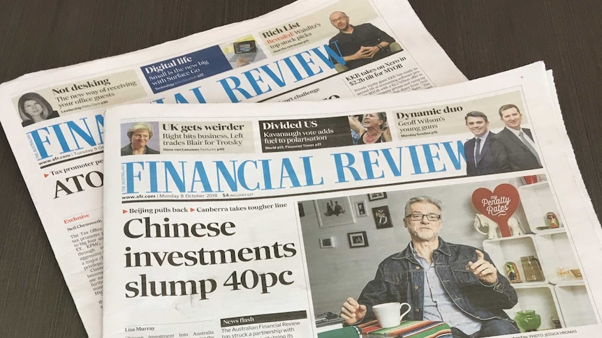 Two Australian Financial Review newspapers sitting on a table.