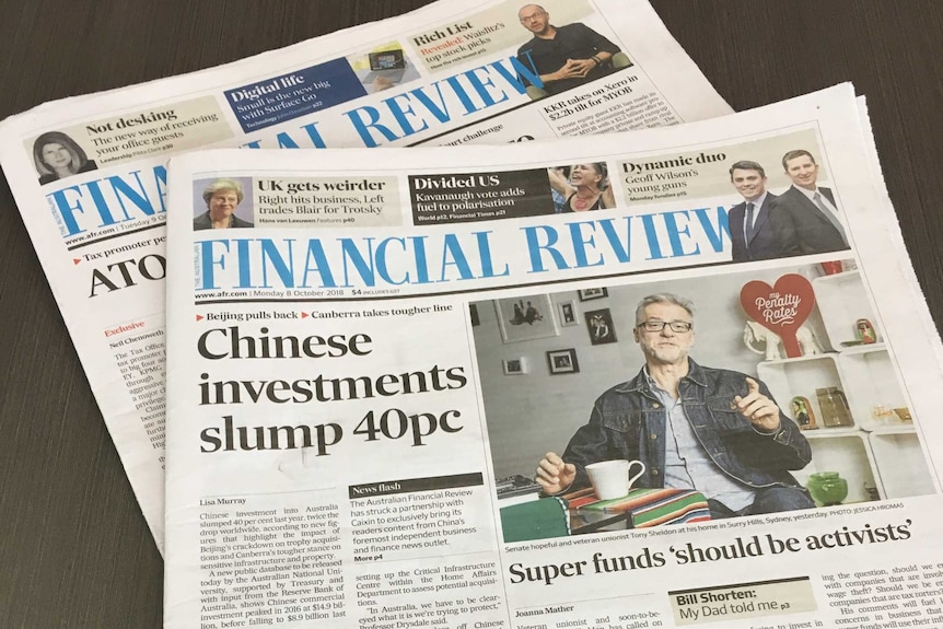 Two Australian Financial Review newspapers sitting on a table.