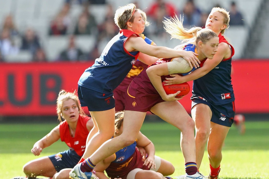 Tayla Harris of Queensland is tackled by Melbourne Demons' Jessica Cameron