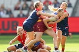Queensland's Tayla Harris is tackled by Melbourne's Jess Cameron in AFL women's game at MCG.