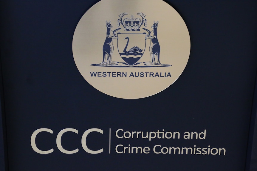 Signage inside the Corruption and Crime Commission office in Perth, white text on black background with WA coat of arms