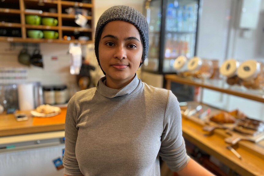 Dilly Amalshi wearing a grey beanie and turtleneck.