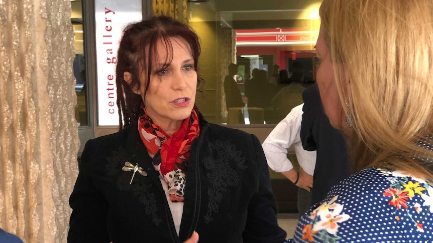 Belinda Valentine speaking to media at an event.