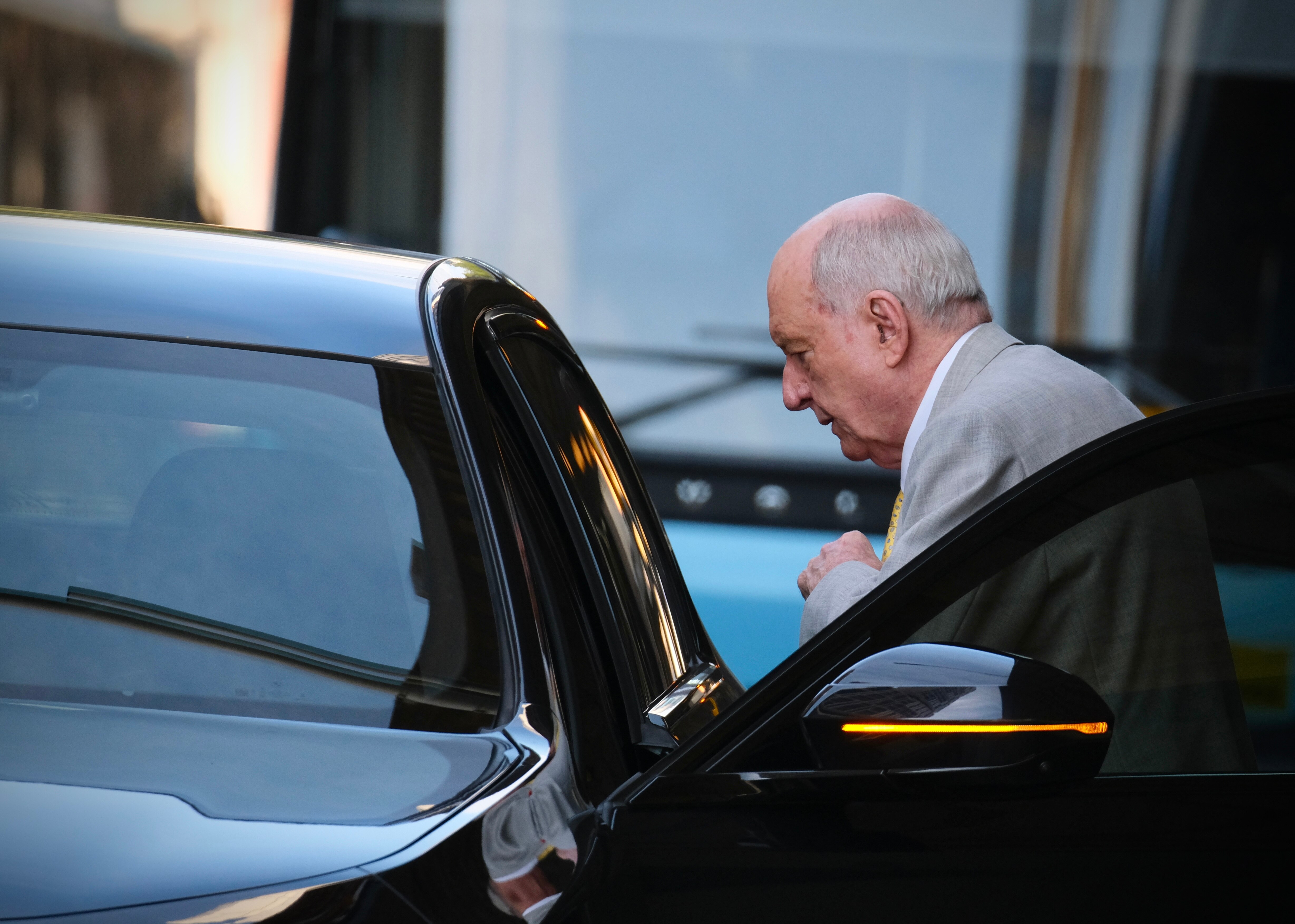 Alan Jones exiting a black vehicle.