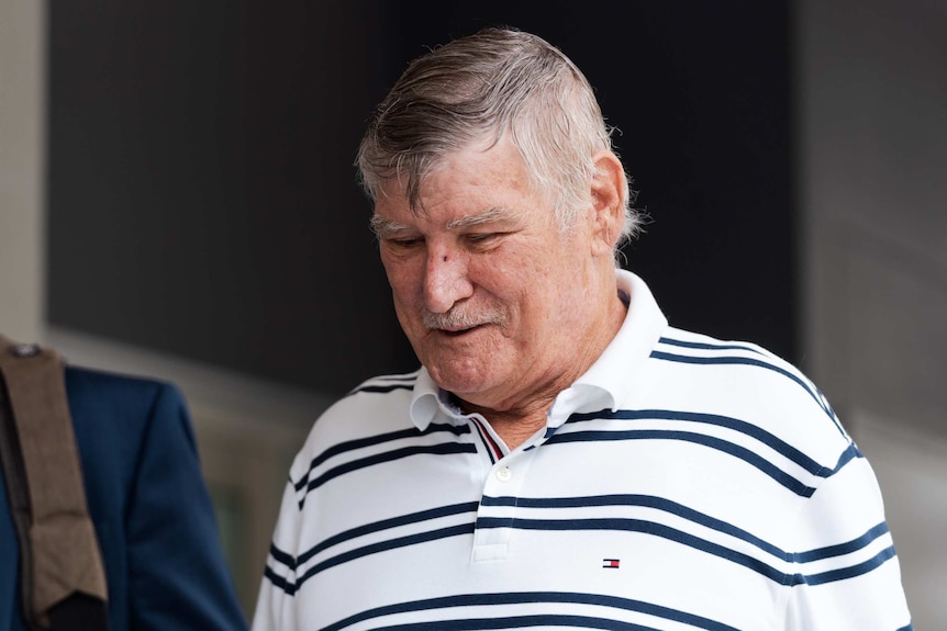 A man with greying hair and wearing a white polo shirt leaves Perth court building