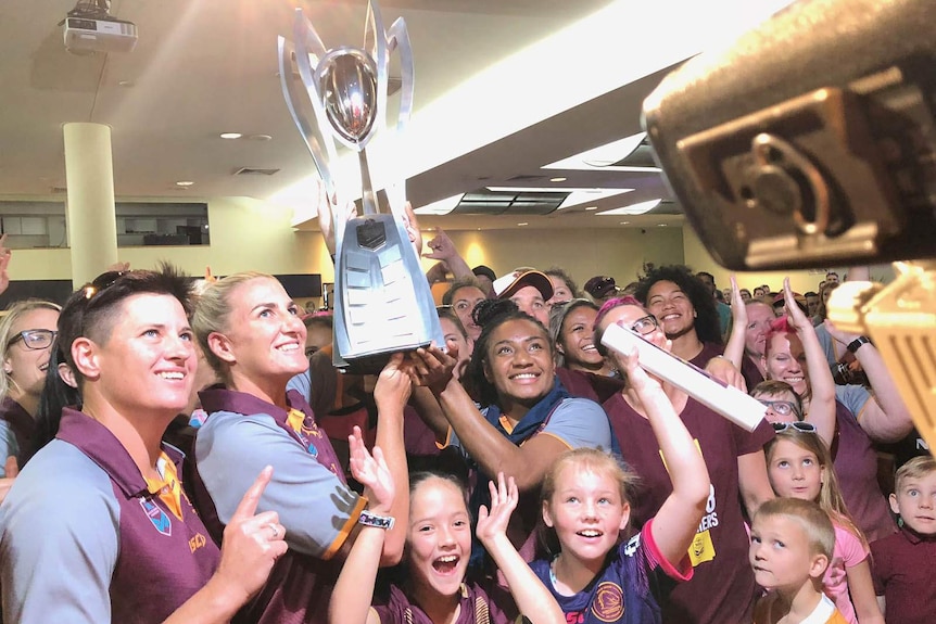 The Broncos women's team show off their trophy