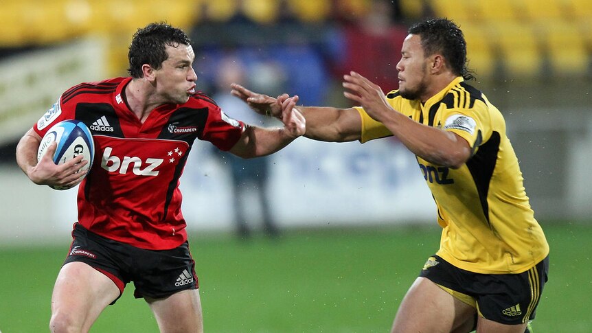 Tom Marshall of the Crusaders is tackled by Alapati Leiua of the Hurricanes.