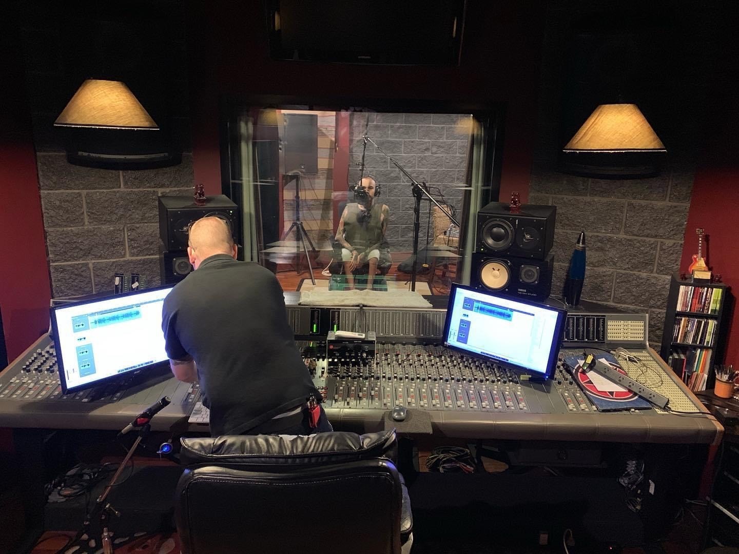 Nathan Tessman, in a recording studio, with a producer sitting at the sound desk