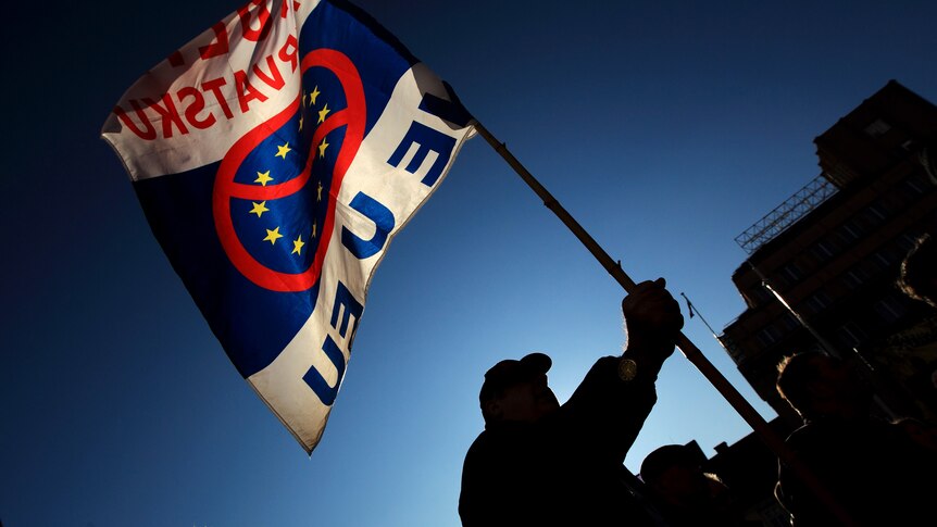 A man waves a flag during a rally to protest against Croatia's EU membership
