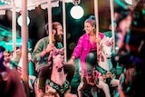 Man and woman ride carousel together holding hands for a story about not feeling like sex in a long-term relationship.