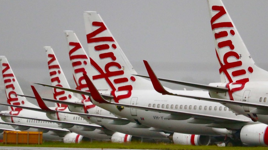 A row of Virgin Australia aircraft grounded at on airport after the company went into voluntary administration in April 2020.