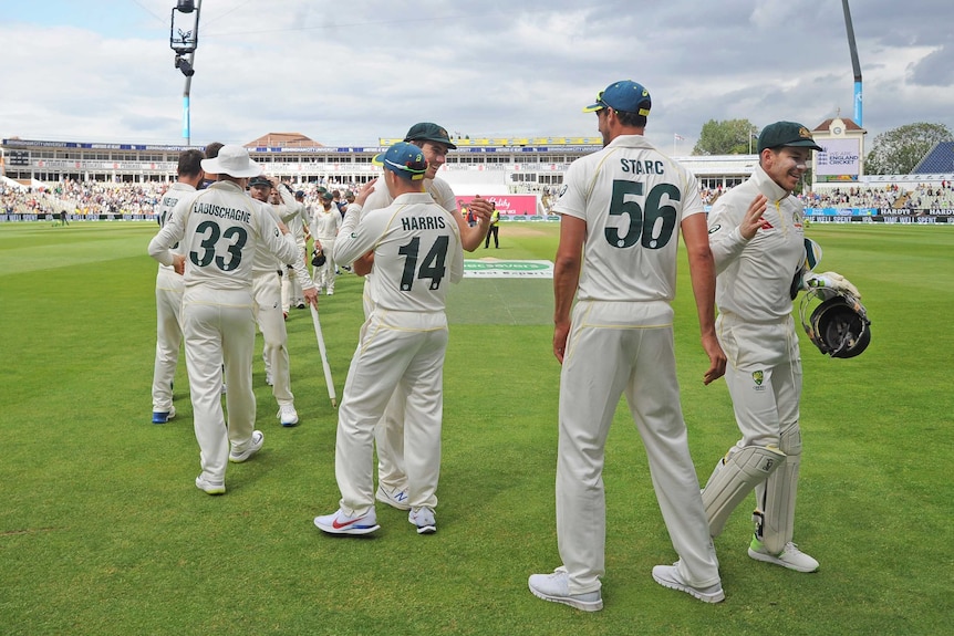 Players line up to give hugs and high fives as they celebrate an Ashes Test win.