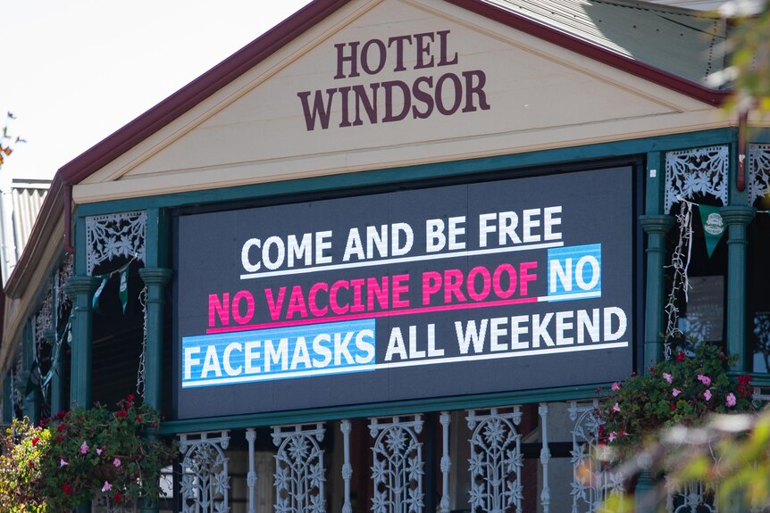 An electronic sign at the front of a pub reads 'Come and be free. No vaccine proof, no facemasks all weekend."