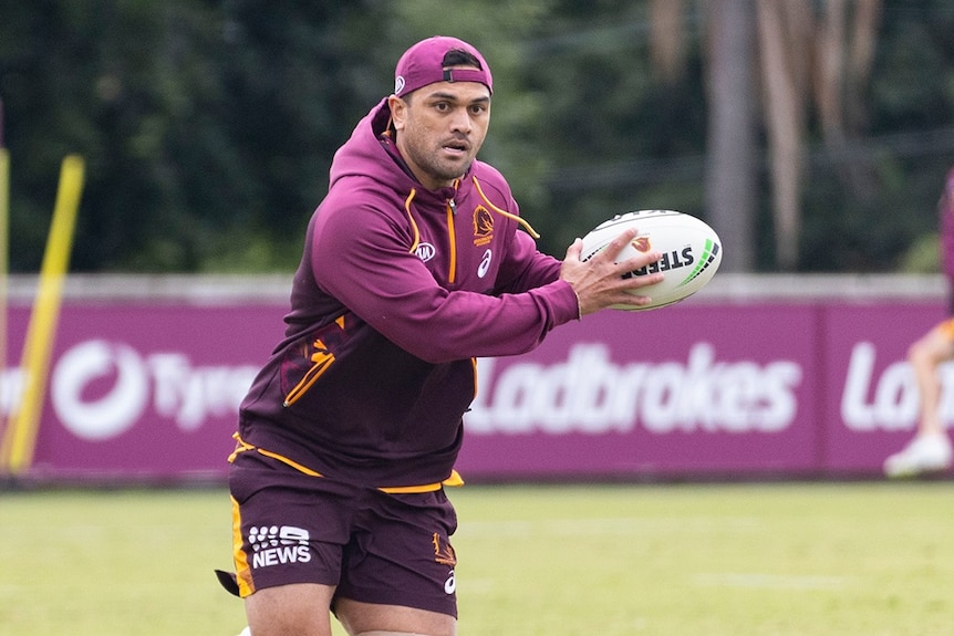Karmichael Hunt wears a backwards cap as he runs with a rugby league ball at Brisbane Broncos training.