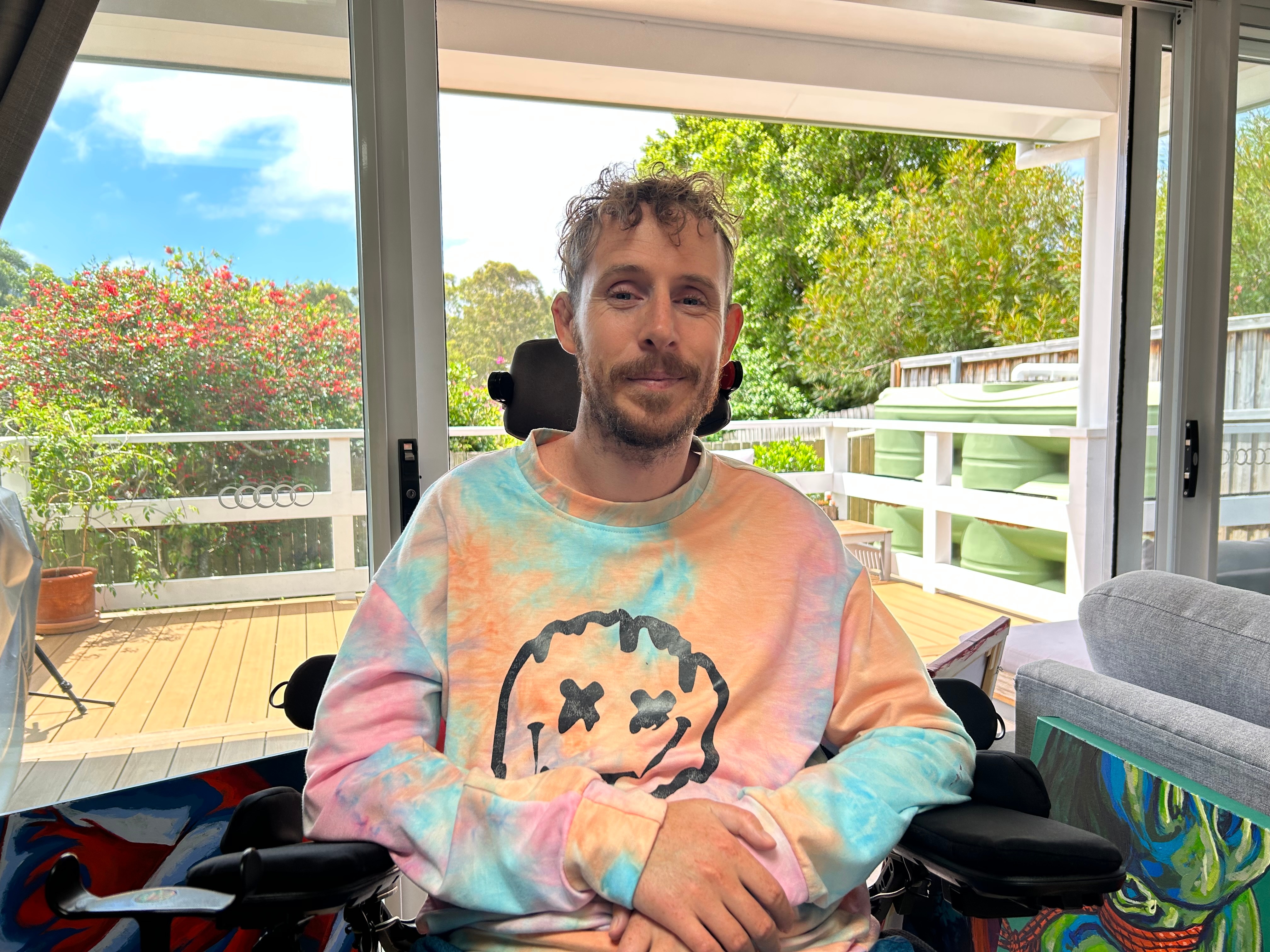 Man in wheelchair smiles in a home
