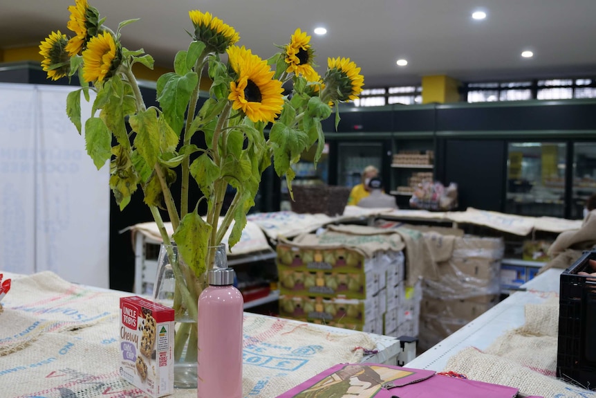 A vase of sunflowers stands on a shelf at the OzHarvest Waterloo market, 2020.