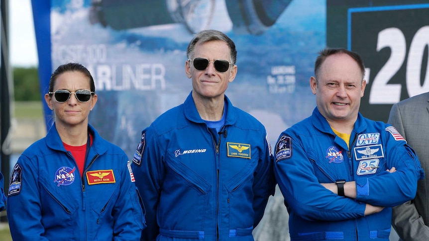 Nicole Mann, Chris Ferguson  and Mike Fincke pose for photo wearing blue jumpsuits.