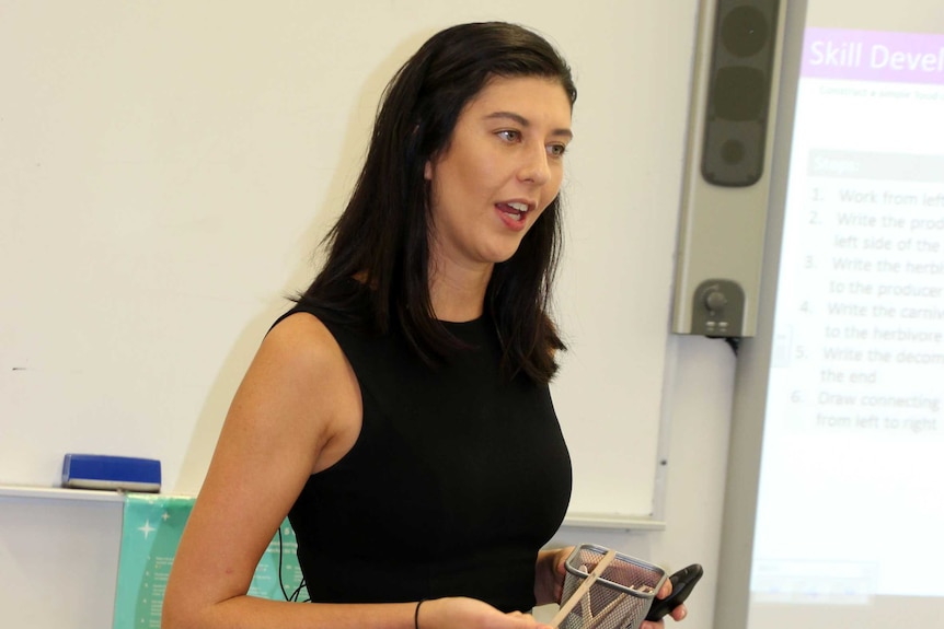 Armadale Senior High School science teacher Arnah Mallon in a classroom holding a popstick.