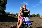 Two girls ride a dirt bike in Moree, NSW