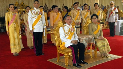 Thailand's King Bhumibol Adulyadej and Queen Sirikit sit infront of the Thai Royal family at the Royal Plaza on June 9, 2006 ...