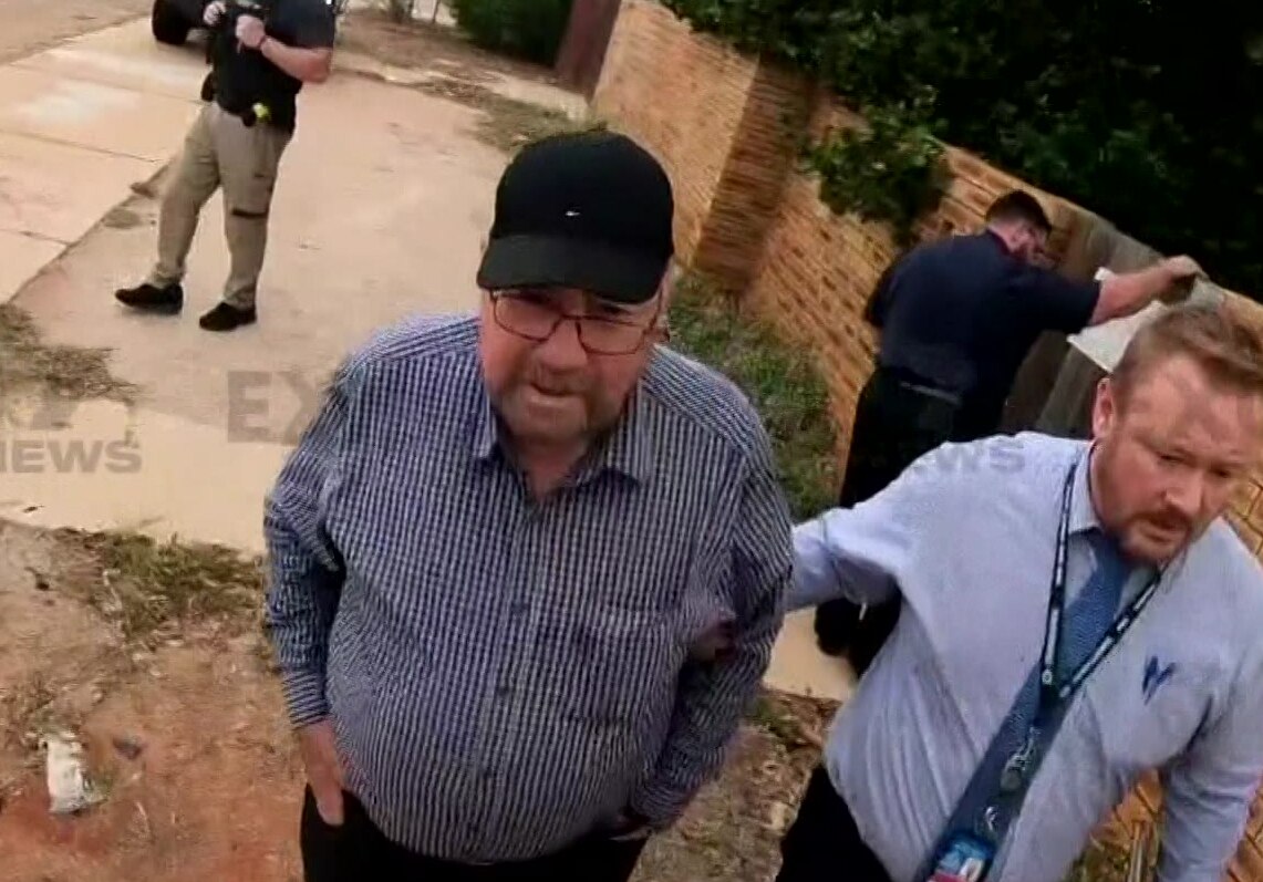 Bishop Saunders being led away by police 