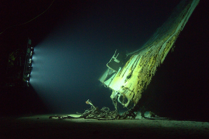 A ship's bow illuminated under water.