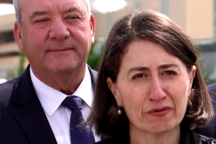 Daryl Maguire stands behind Gladys Berejiklian during a media conference.