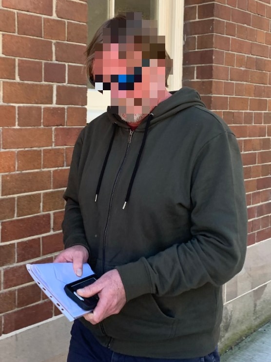 A man with his face pixelated.