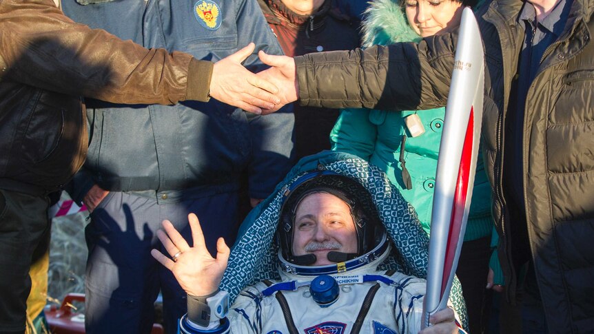 Russian cosmonaut Fyodor Yurchikhin holds the Sochi Olympic torch
