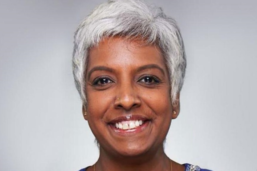 A woman smiles in a close-up portrait.