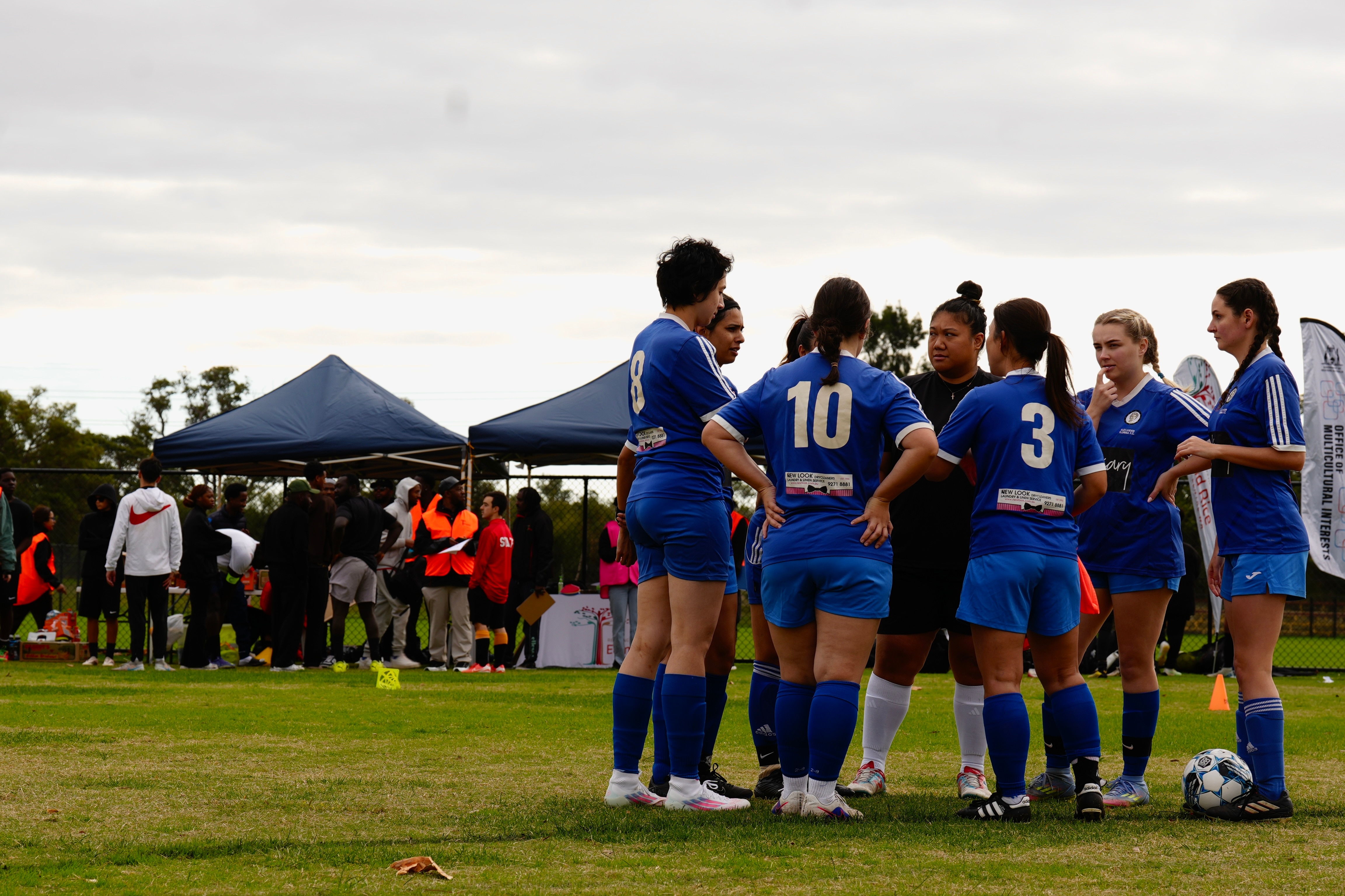 A team huddles on a soccer field.