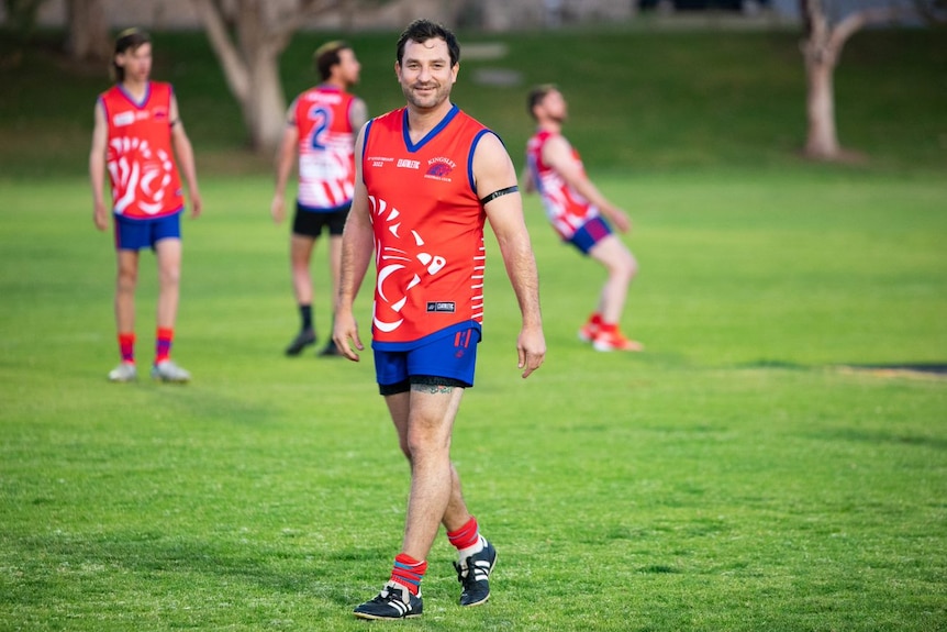 A wide shot of Brad walking on the field wearing a black armband. 