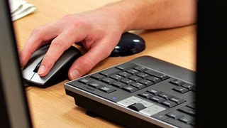 A hand using a mouse to surf the internet