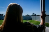 A woman looking into her backyard.