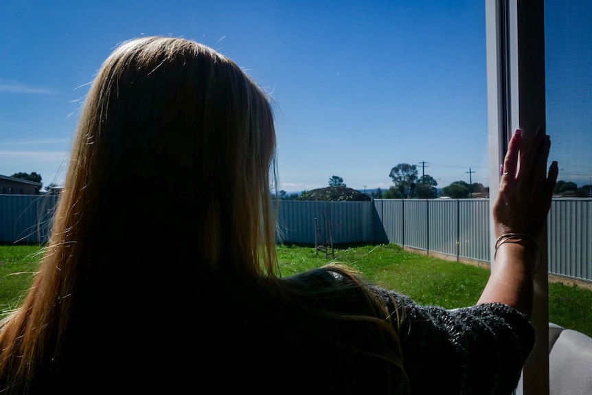 A woman looking into her backyard.